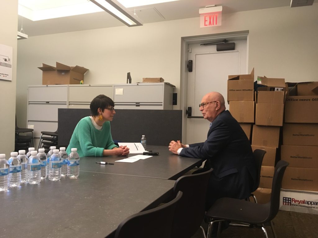 Two people sitting at a table with laptops