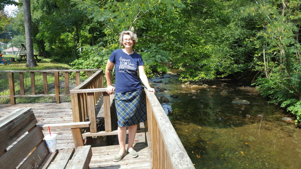 A woman standing on the side of a bridge.