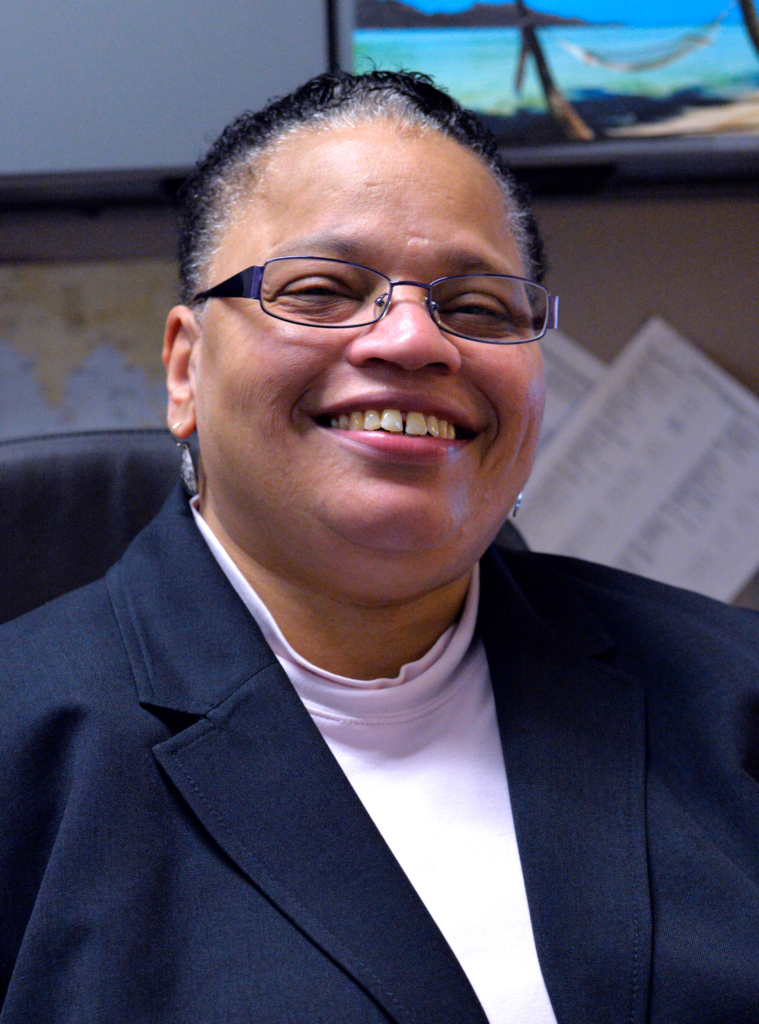 A woman sitting in an office chair smiling.